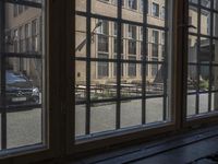 looking out an open window on a city street outside of an apartment building, from an alley