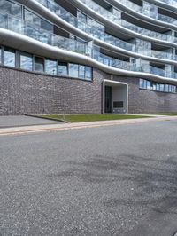 an image of a big building on the side of the street - some building behind it is a green grassy field