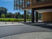 a road through which is a large modern building with an awning over it's entrance