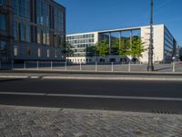 a street light next to an empty road in front of a building with a traffic light on top of it