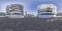 a street that is lined with buildings and rocks around it that have circular views from inside