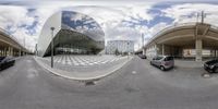 several cars and some tall buildings on the street and in the background, there are two circular mirrors