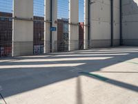 a parking garage with several small sections of concrete in front of a fenced off area