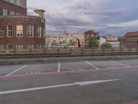 a parking lot with a train track in front of it and a large building in the distance