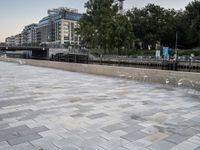 a man riding on the back of a skateboard next to a park area with clear chairs and tables