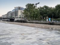 a man riding on the back of a skateboard next to a park area with clear chairs and tables