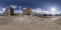 360 view of the street with several buildings and sky background taken from inside a fish eye lens