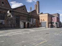 a large old brick building with windows on the side of it's sides and a big, broken clock hanging in front of the door