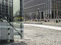 a large glass container is sitting in an open courtyard area on the sidewalk on the side