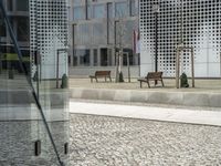 a large glass container is sitting in an open courtyard area on the sidewalk on the side