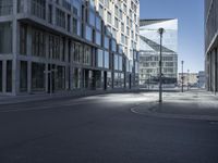 a city street with two tall buildings on either side of it, one is empty