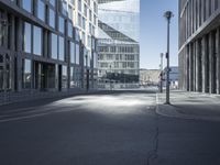 a city street with two tall buildings on either side of it, one is empty