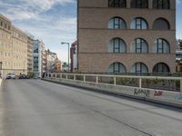 a man riding his skateboard down an empty city street on a bridge over looking the ocean