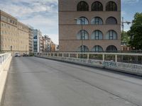 a man riding his skateboard down an empty city street on a bridge over looking the ocean