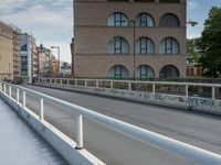 a man riding his skateboard down an empty city street on a bridge over looking the ocean