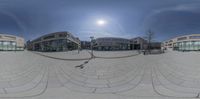 a 360 - ray photograph shows three buildings at different angles and a sidewalk with some people