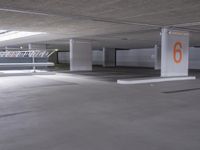 a large empty parking garage with three floors and two orange numbers on the wall below them