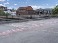 an empty parking lot with a red line painted on it in front of some buildings