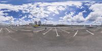 there is a 360 - zoom image of parking lot with a cloudy blue sky and a street light