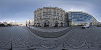 a fisheye lens image of two buildings in the city with people standing near them