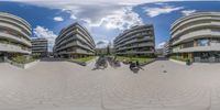 a 360 - lens image of several buildings with bikes parked near one another in front