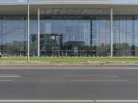 the front of the modern glassed building is reflected in the windows of its front