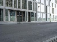 empty street in front of stone and glass buildings next to road lamp post and buildings