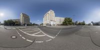 a fisheye lens shot of a city street and intersection at the same time with buildings on either side