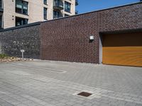 a brick wall with a small parking space near it and two garage doors opened to the street