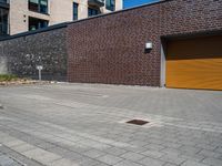 a brick wall with a small parking space near it and two garage doors opened to the street