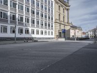 the empty empty street is next to two buildings with large windows on one side of the building