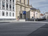 the empty empty street is next to two buildings with large windows on one side of the building