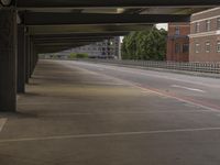 an empty parking garage with parked cars in it's lot next to the roadway