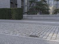 a sidewalk with a sidewalk drain in front of a building that says manhattan public library