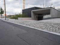 a sidewalk in front of a concrete structure and stairs on either side of it,