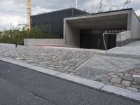 a sidewalk in front of a concrete structure and stairs on either side of it,