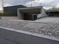 a sidewalk in front of a concrete structure and stairs on either side of it,