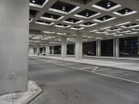 a parking garage with open shelving, empty street and cars driving on the road