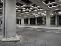 a parking garage with open shelving, empty street and cars driving on the road