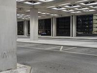 a parking garage with open shelving, empty street and cars driving on the road