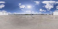 an 360 - mirror photograph shows a parking lot with a building in the background and cars parked nearby