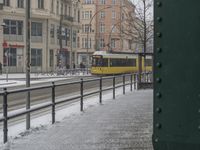 a bus stopped on the side of a street in front of a green sign and snowy street