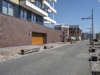 a bricked area with a parking lot on each side of it and some buildings in the back ground