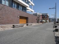 a bricked area with a parking lot on each side of it and some buildings in the back ground