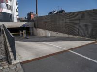 an empty parking lot in front of a tall building with doors to allow people to leave