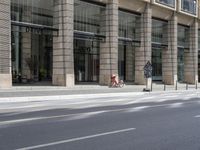 the front of an office building on a city street, along with the street and road signs