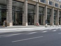 the front of an office building on a city street, along with the street and road signs