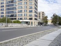 the street is lined with buildings and cobblestone steps and benches and umbrellas