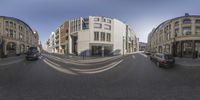 a fish - eye view of a street with cars and buildings in the distance from a perspective lens