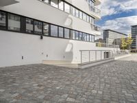 the brick walkway in front of a tall building on the opposite side with the stair